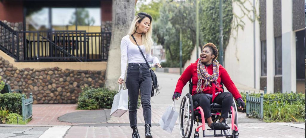 Accessible Holiday Shopping for the Disabled - A girl walking with another girl in a wheelchair