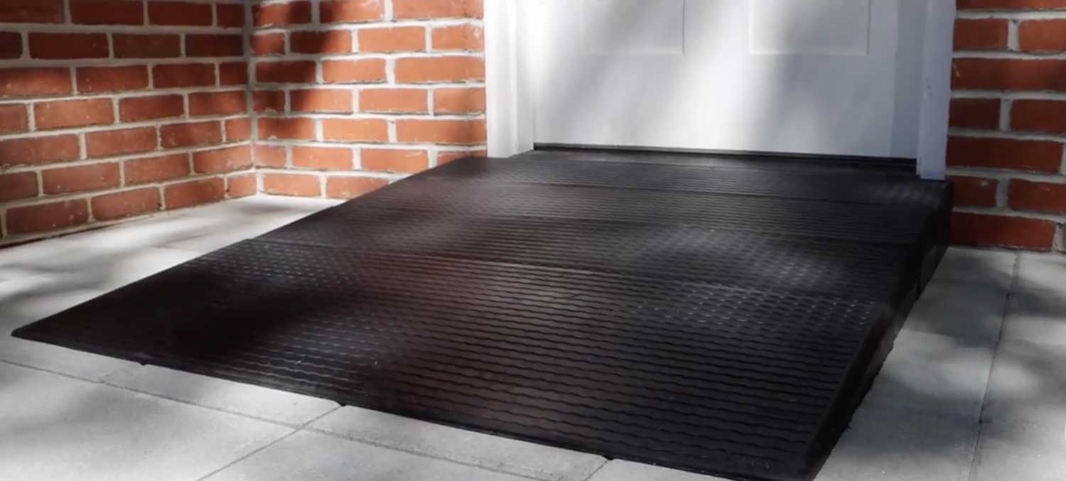 A rubber threshold access ramp in front of a doorway