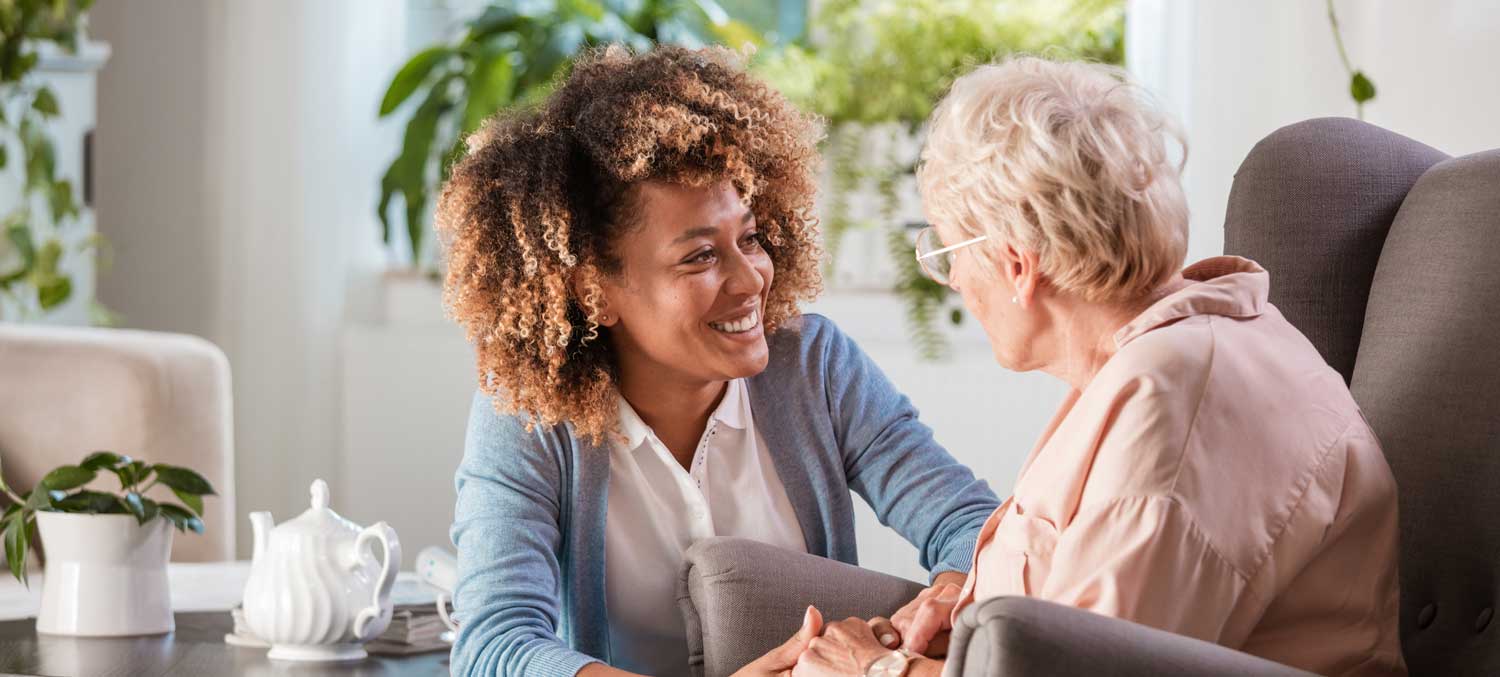 Lady caregiver tending to an elderly woman