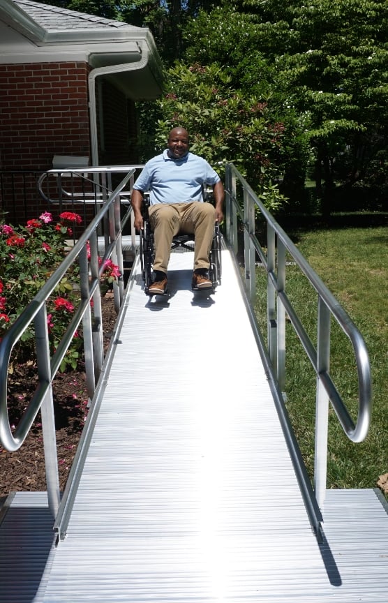 A gentleman in a wheelchair coming down a ramp
