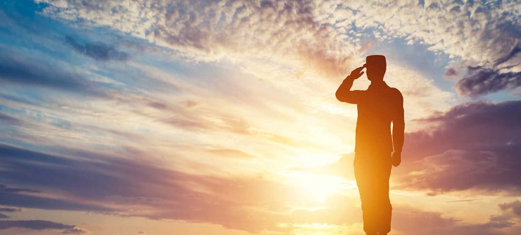 Soldier Saluting with a Sunset Behind Him