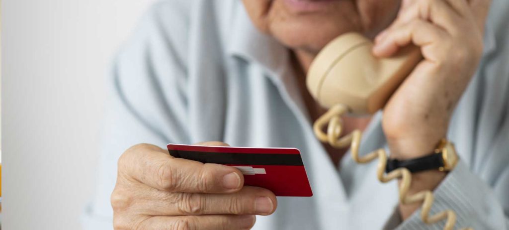 Elderly Man on the Phone with a Credit Card - Protect Yourself from Scams