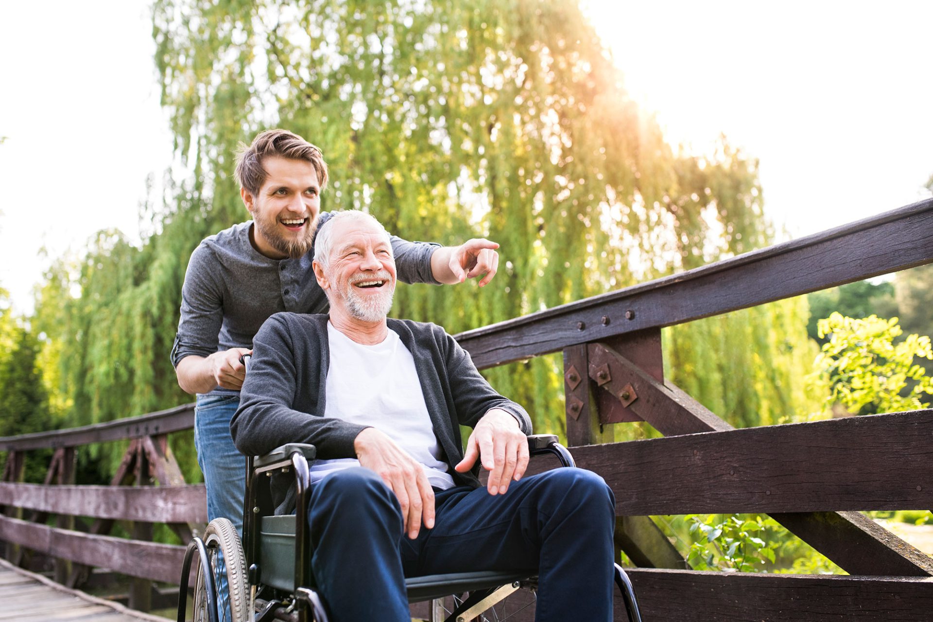 Son Pushing Dad in a Wheelchair on a Wooden Ramp