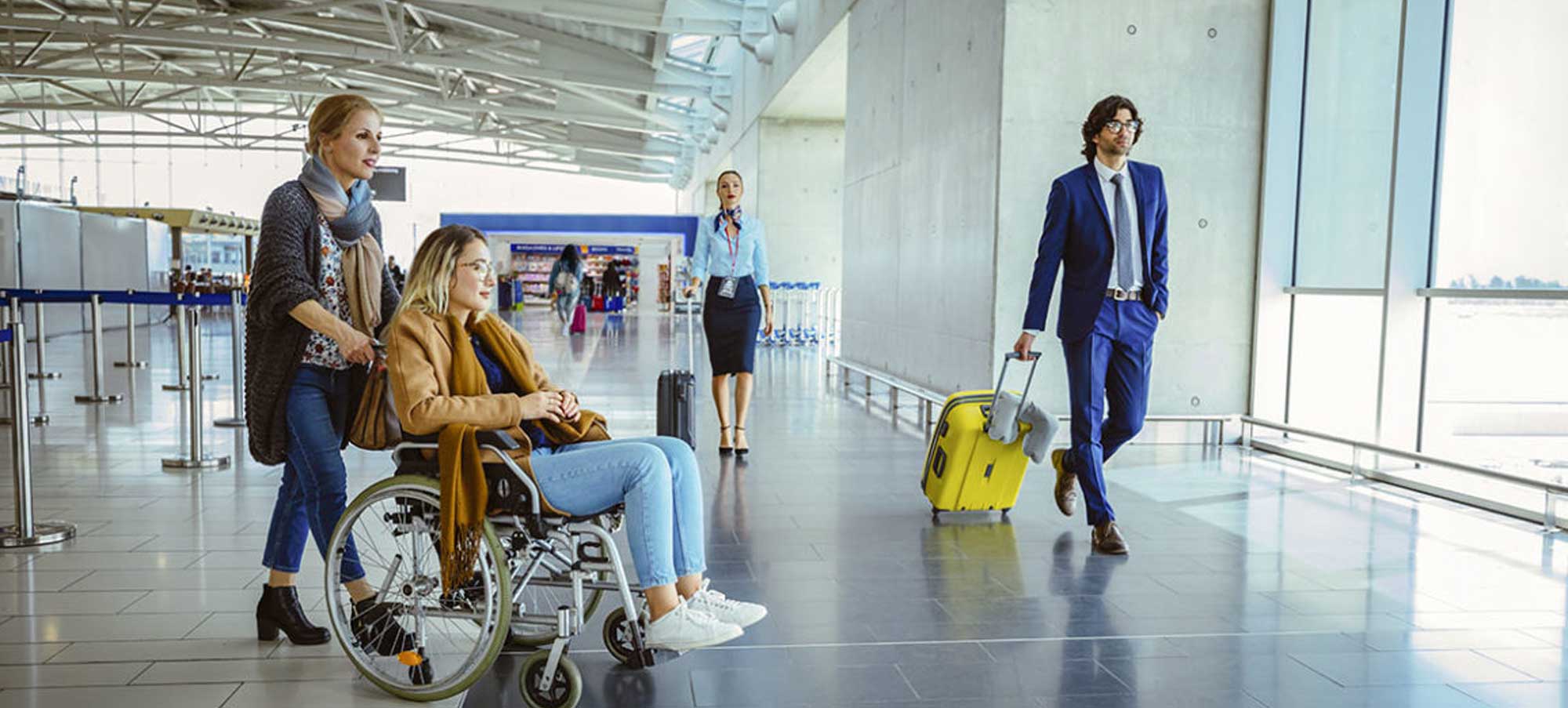 Young woman being pushed in a wheelchair in an airport
