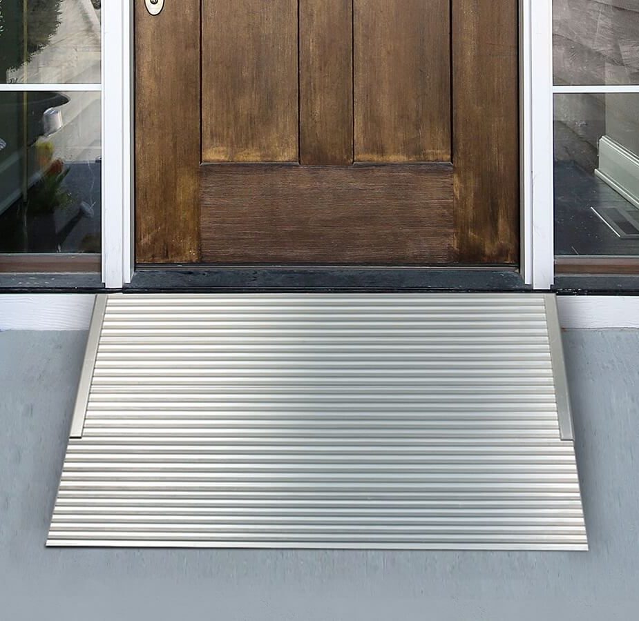 Aluminum threshold ramp installed in front of a wooden door