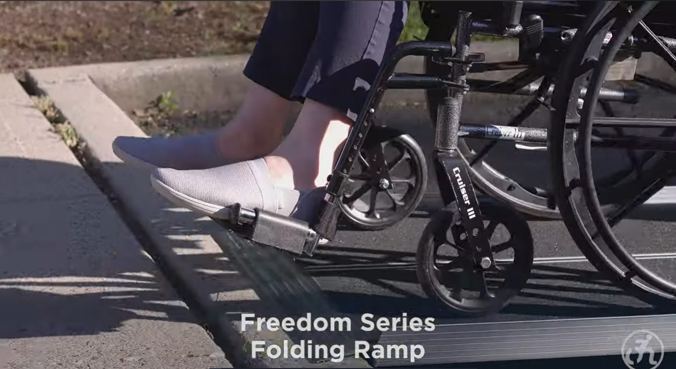 Wheelchair Being Pushed on an Aluminum Folding Ramp