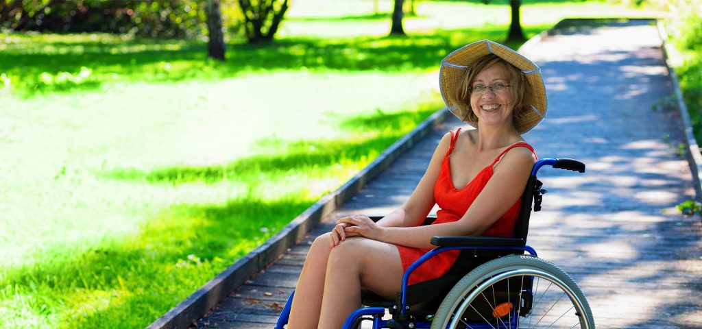 Woman in wheelchair outdoors, through a ramp