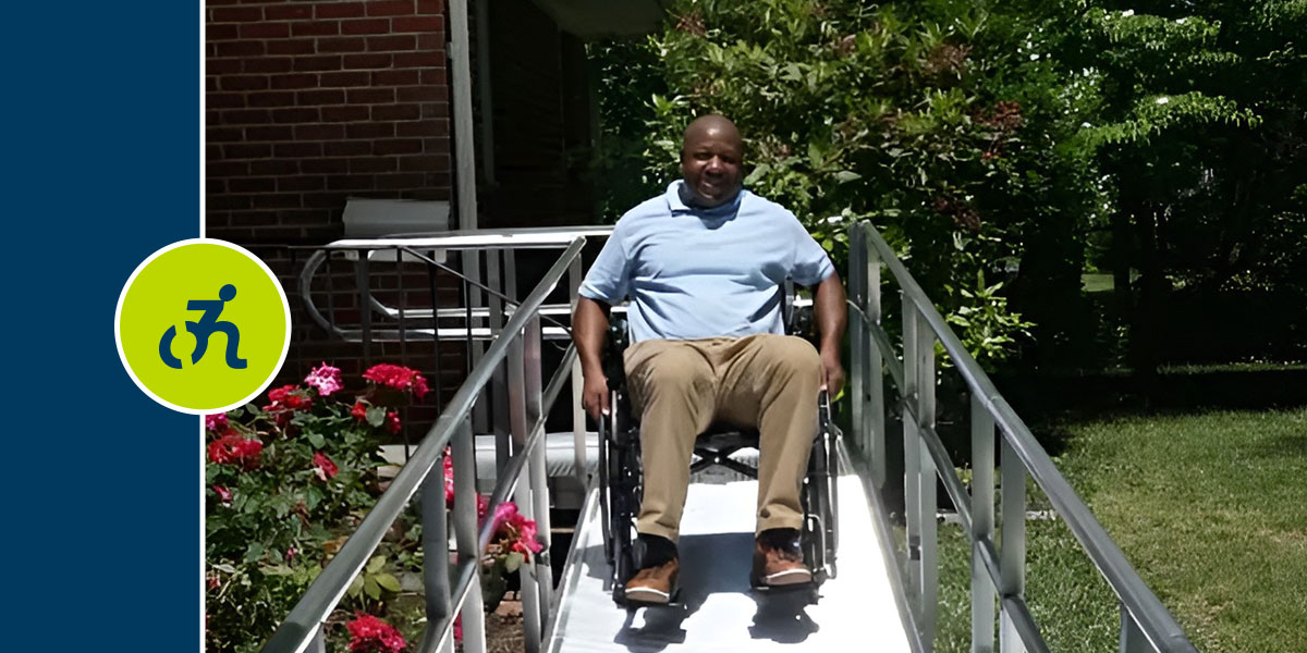 Man smiling while rolling down a wheelchair ramp